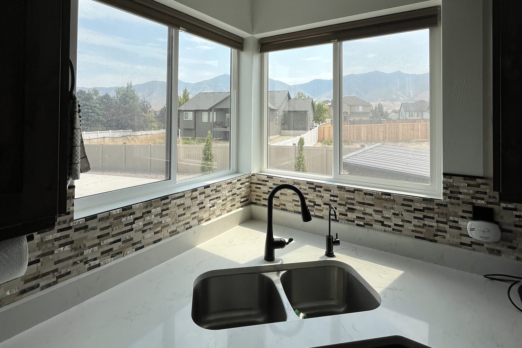 Bright residential kitchen with corner windows overlooking mountain views